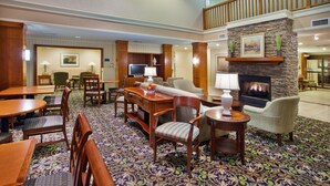 Een hotellobby met een open haard, zithoek en een televisie.