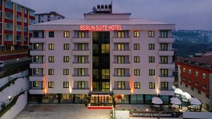 Un hotel de diverses plantes amb un cartell destacat que diu "Berlin Suite Hotel".