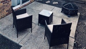 A patio area with three black wicker chairs and a small square table. - Location!! Minutes from L’Auberge/LSU/DOWNTOWN (Baton Rouge)