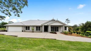 A two-story house with a garage, a covered driveway, and a well-maintained lawn. - Modern Farm Stay - South Coast (Yatte Yattah)