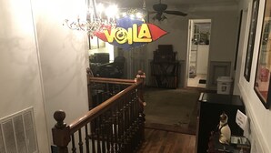 Un escalier avec une rampe en bois et un lustre.
