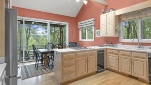 Una cocina amplia con armarios de madera, una isla grande y vistas al exterior a través de las ventanas.