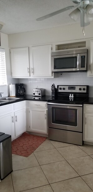 Enjoy cooking in this well-equipped kitchen with stainless steel appliances and white cabinetry.