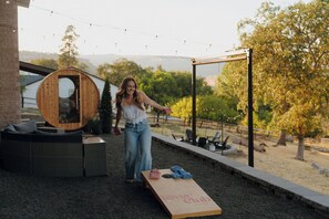 A wooden structure with a circular opening, a wooden bench, and a wooden board with 'Ring Club' text. - Epic Game Room, Outdoor Movie Night, Hot Tub, Fire Pit (The Dalles)