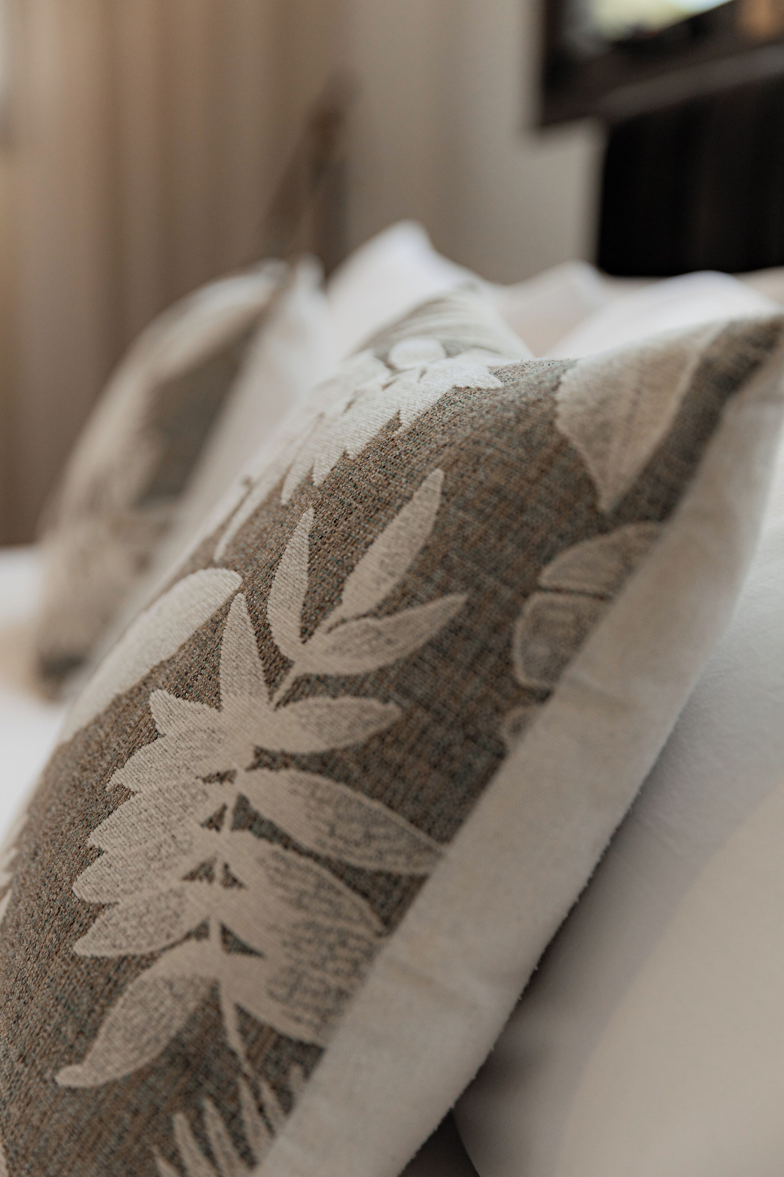 A close-up of a pillow with a floral pattern.