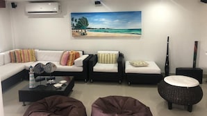 Una sala de estar moderna con un juego de sofá, una mesa de centro y un otoman redondo.