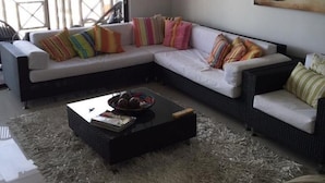 Una sala de estar moderna con un sofá modular, una mesita de centro y un ventanal grande.