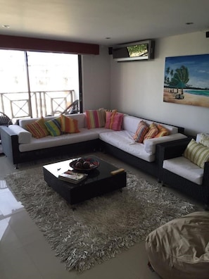 A modern living room with a sectional sofa, a coffee table, and a large window.