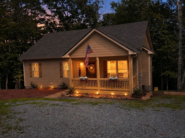 A two-story house with a porch, an American flag, and a wreath. - Cozy Day Break! Hot Tub, Fire Pit, Horse Shoes, Near Nottley Lake (Morganton)