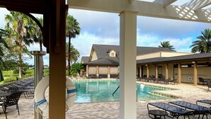 A pool area with lounge chairs and a lifeguard stand.