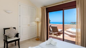 A hotel room with a bed, a chair, a lamp, and a view of the ocean through a sliding glass door. - Nice duplex penthouse with the best sea views, luxury urbanization (Marbella)