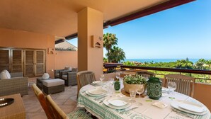 A dining area with a table set for four, overlooking a scenic ocean view. - Nice duplex penthouse with the best sea views, luxury urbanization (Marbella)