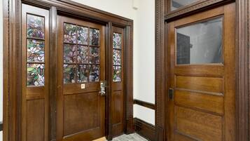 A wooden double door with stained glass panels and a doorbell.