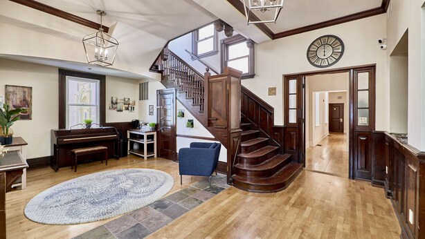 A spacious foyer with a grand staircase, a piano, and a large rug. -  White House at Grand Central (St. Louis)