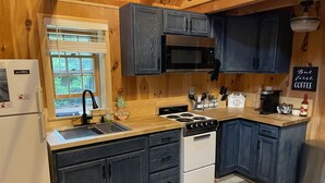 Une cuisine moderne avec des meubles de couleur sombre, une cuisinière en acier inoxydable et un coin café.