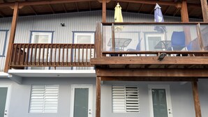 A two-story building with a balcony, large windows, and a wooden ceiling. - Located at Poblado Boqueron, Just Perfect for You! (Cabo Rojo)