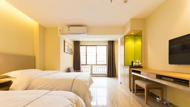 A hotel room with two beds, a desk, a chair, a flat-screen TV, and a window with curtains. - Lanzhou Jinyuan Zhijia Hotel (Lanzhou)