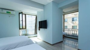 A hotel room with two beds, a TV, a window, and a balcony. - Lanzhou Jinyuan Zhijia Hotel (Lanzhou)