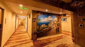 A hotel hallway with a mural, carpeted floor, and a fire extinguisher. - Lanzhou Jinyuan Zhijia Hotel (Lanzhou)