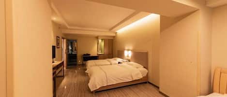 Una habitación de hotel con una cama grande, un escritorio y un espejo.
