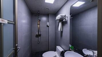 A compact bathroom with a toilet, bidet, and sink.