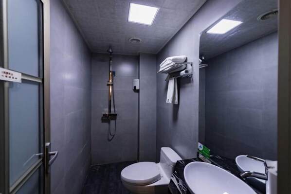 Un baño pequeño con inodoro, bidé y lavamanos.