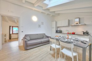 A modern kitchen with white cabinets, a built-in microwave, and a gas stove.