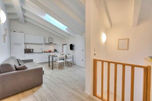Un interior moderno con cocina, comedor y escalera.