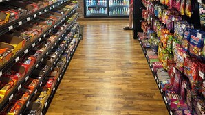 A grocery store aisle with snacks, beverages, and refrigerated sections.