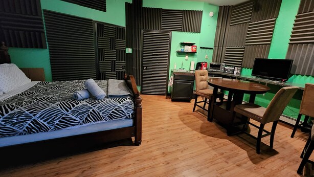 Ett litet rum med en säng, ett litet kök och en matplats.