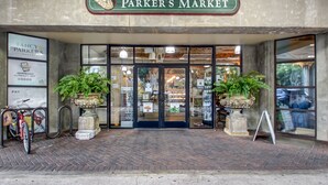 The entrance to Parker's Market with a brick facade, large glass doors, and potted plants.