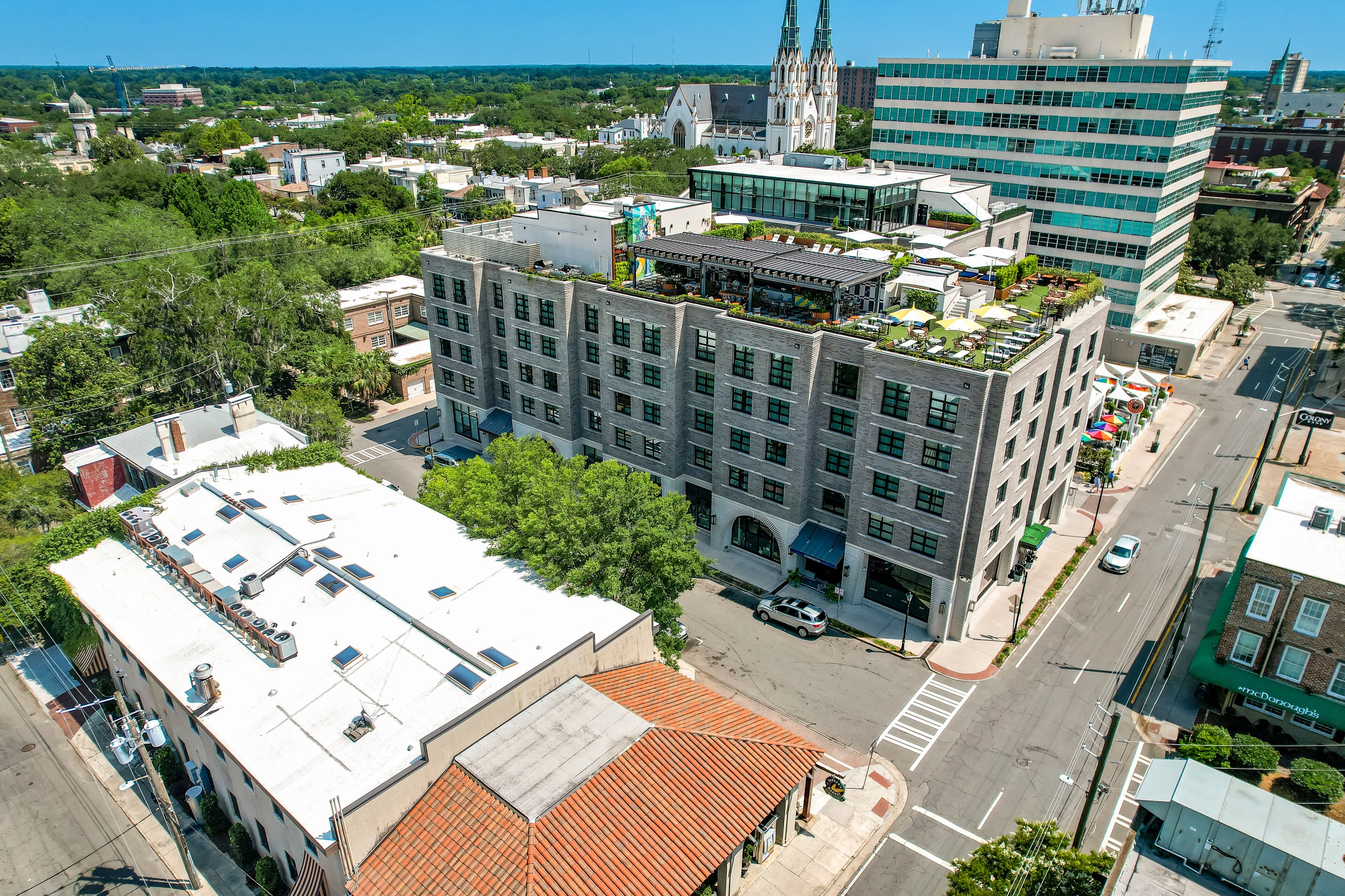 Un immeuble urbain à plusieurs étages, doté d’un toit plat et comprenant des espaces à usage commercial et résidentiel.