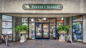 L’entrée du marché Parker, avec son sol pavé de briques, deux plantes en pot et un support à vélos.