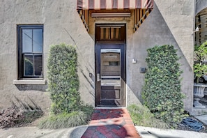 A building with a black door labeled "The Parker's," a window, and a brick pathway leading to the entrance.