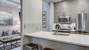 A modern kitchen with a white countertop, stainless steel appliances, and a built-in microwave. - Perfect For Large Groups, Heated Pool Access (Savannah)