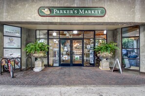 The entrance to Parker's Market with a brick facade, large glass doors, and potted plants.