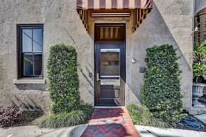 Stunning entrance with a dark door and well-manicured hedges.