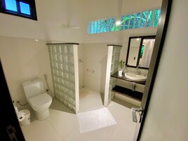 A bathroom with a toilet, bidet, and sink.