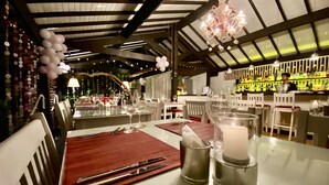 Ein Restaurant mit gedeckten Tischen, einer Bar und einer Kristallleuchter.