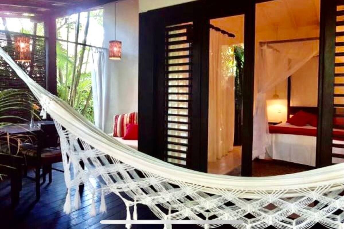 Una hamaca en una habitación con una cama y una mesa.