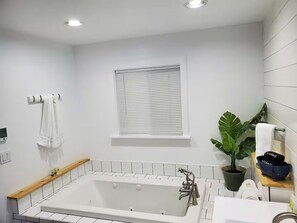 Tina con regadera, tina de hidromasaje, secadora de cabello, toallas 