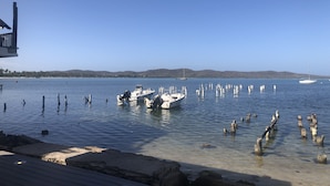 A marina with boats docked, clear water, and a distant shoreline with hills. - Perfect Location, Inside Poblado Boqueron (Boquerón)