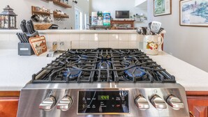 A kitchen with a stainless steel stove, a digital clock, and various kitchen items on the counter. - Experience the Private Pond & Dock |Relax by the Fire |Raving Reviews at Blackjack Acres|Truist Park (Marietta)
