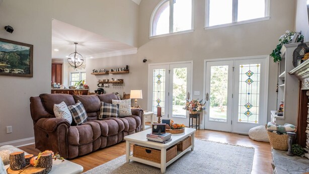 A spacious living room with a brown leather sofa, a coffee table, and a fireplace. - Experience the Private Pond & Dock |Relax by the Fire |Raving Reviews at Blackjack Acres|Truist Park (Marietta)