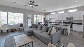 A spacious living room with a gray sectional sofa, a wooden coffee table, and a ceiling fan. - Great Location w/ Private Heated Pool, Near Hiking/Golfing/Shopping/Dining & Mayo Clinic + FREE GOLF (Phoenix)