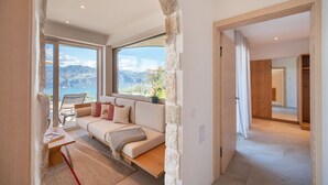 Ein modernes Wohnzimmer mit Sofa, Tisch und Meerblick.