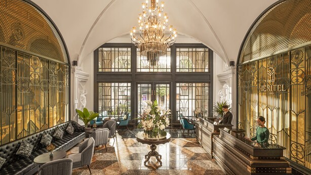 A grand lobby with a high ceiling, a chandelier, a reception desk, and a seating area with a sofa and chairs. - Meritel Hanoi (Hanoi)