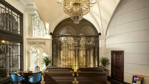 A lobby with a grand chandelier, a reception desk, and a statue. - Meritel Hanoi (Hanoi)