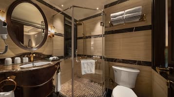 Une salle de bain moderne avec une douche à parois de verre, un meuble-lavabo en marbre et des toilettes blanches.