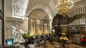A luxurious lobby with a grand chandelier, a black leather sofa, and a piano. - Meritel Hanoi (Hanoi)